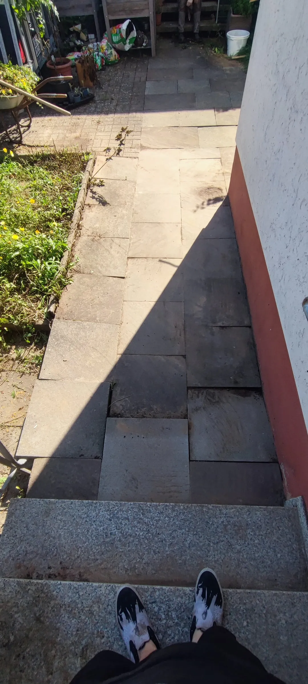 Hauszugang vorher: abgesackte, ungleichmäßige Platten mit Stolperkanten